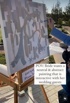 a woman is painting on an easel in front of a sign that says pov bride wants a neutral & abstract painting that is interactive with her wedding guests