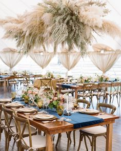 the tables are set with blue linens and gold place settings for an elegant reception