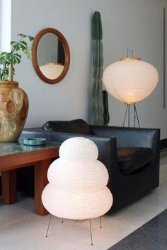 a living room filled with furniture next to a mirror and potted plant on top of a table