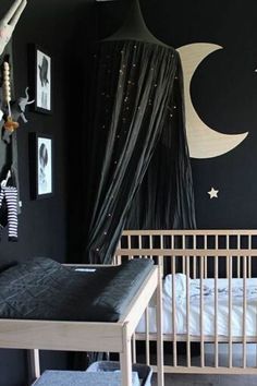 a baby's room with black walls and white crib