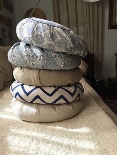 a stack of pillows sitting on top of a bed