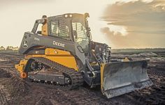 a yellow and black bulldozer is in the dirt