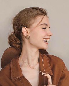 a young woman smiles as she poses for the camera with her hand on her hip