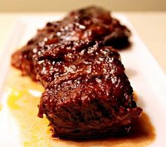 two pieces of meat sitting on top of a white plate