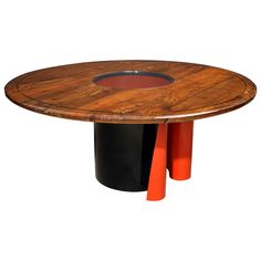 a wooden table with two black and orange pedestals on it's sides, in front of a white background