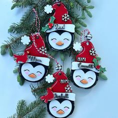 three penguin ornaments hanging from a christmas tree