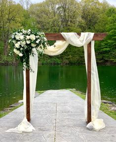 an outdoor wedding ceremony setup with white flowers and greenery