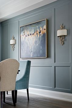 a living room scene with focus on the chair and wall art above the couches