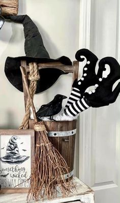 halloween decorations on top of an old wooden bucket with brooms and other items in it