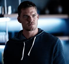 a man in a black hoodie looking at the camera