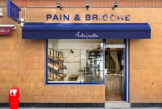 a store front with blue awnings and windows