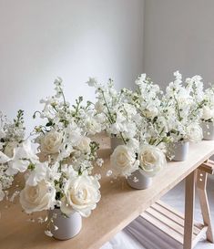 white flowers are arranged in vases on a table