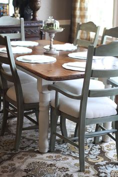 a dining room table with chairs and plates on it