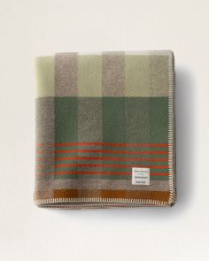 a green and brown checkered blanket sitting on top of a white table