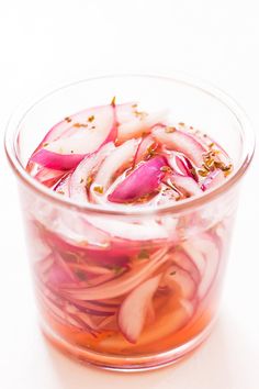 a glass bowl filled with sliced up radishes on top of a white table