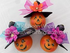 three oranges with faces painted on them are sitting next to each other and one is wearing a witch's hat