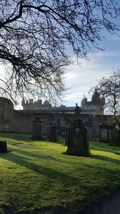 an old cemetery with tombstones in the foreground and a castle in the background