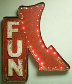 a red neon sign with the word fun on it's side and an arrow