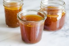 two jars filled with liquid sitting on top of a white tablecloth covered countertop