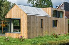 a small wooden house sitting on top of a lush green field next to a river