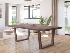 a large wooden table sitting on top of a hard wood floor next to a living room