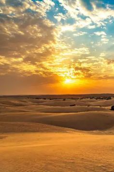 the sun is setting over some sand dunes