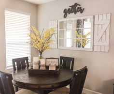 a dining room table with chairs and a vase filled with flowers on top of it