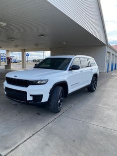 a white jeep parked in front of a building