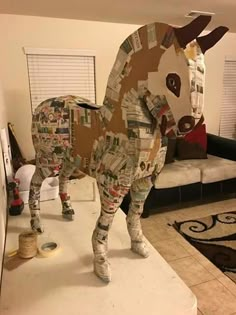 a cow made out of newspaper sitting on top of a counter