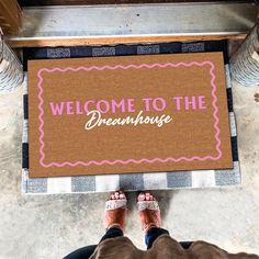 someone standing in front of a welcome mat that says, welcome to the dreamhouse