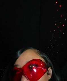 a woman wearing a red mask with fireworks in the background