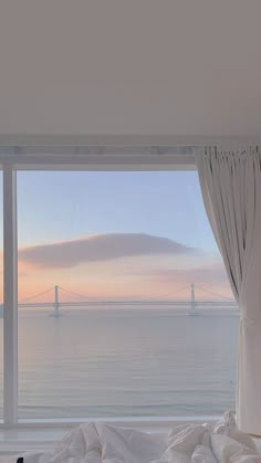 a bedroom with a large window overlooking the ocean