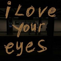 the words i love your eyes written in brown ink on a black background with people walking by