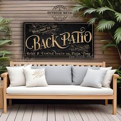 a couch sitting on top of a wooden floor next to a wall with a sign that says back patio