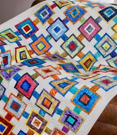 a colorful quilt is draped on top of a chair