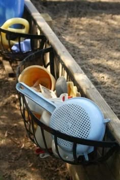 a basket filled with trash sitting on top of a wooden fence