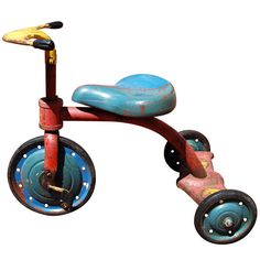 an old tricycle is painted blue and red