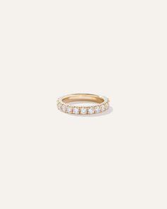 a gold ring with five small diamonds on the inside and outside, set against a white background