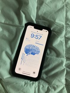 an iphone with the brain on it laying on a bed covered in green sheets and white sheets