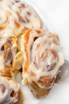 cinnamon rolls with icing on a white plate