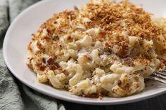 a white plate topped with macaroni and cheese covered in crumbled toppings