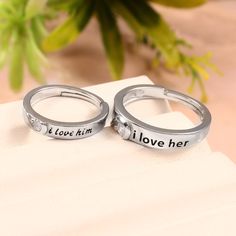 two silver rings that say i love him and her