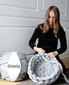 a woman sitting on the floor next to two large objects