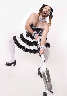 a man dressed as a maid with a vacuum cleaner in his hand and mouth open