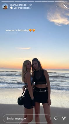 two beautiful young women standing next to each other at the beach in front of the ocean