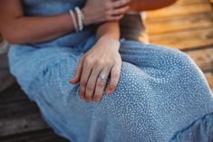 a woman sitting on a bench wearing a ring