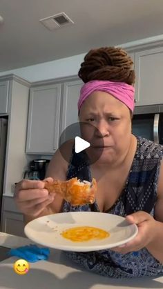 a woman sitting at a table with a plate of food in front of her face