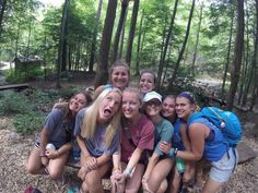 a group of young women posing for a photo in the woods