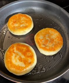 three pancakes cooking in a frying pan on the stove