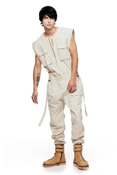 Jonny Cota takes on the summer suit with this season's Sleeveless Canvas Jumpsuit, crafted from soft baby canvas with cargo patch pockets and gun metal hardware detailing throughout. — Cargo patch pockets— Gun metal snaps— Zip closure at center middle— 100% baby canvas suedeSIZE + FIT— Loose, relaxed fit— Adjustable d-ring belt at waist— Model is 6’0 and wearing a size L CARE— Dry clean recommended Romper Men, Men Mode, Jumpsuit Outfits, Baby Canvas, Ripped Jeans Men, Suspenders Men, Suspender Pants, Mens Fashion Wear, Summer Suits